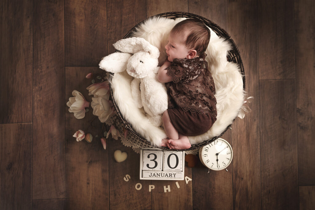 Baby im Körbchen mit Hase, Namen, Blumen und Datumswürfel und Uhr